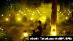 Iranians pray around the graves of "martyrs" in a religious ceremony during the holy fasting month of Ramadan at the Behesht-Zahra cemetery in Tehran.
