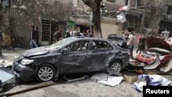 Cars lie wrecked after a suicide car-bomb exploded in the main business district of Damascus on April 8.