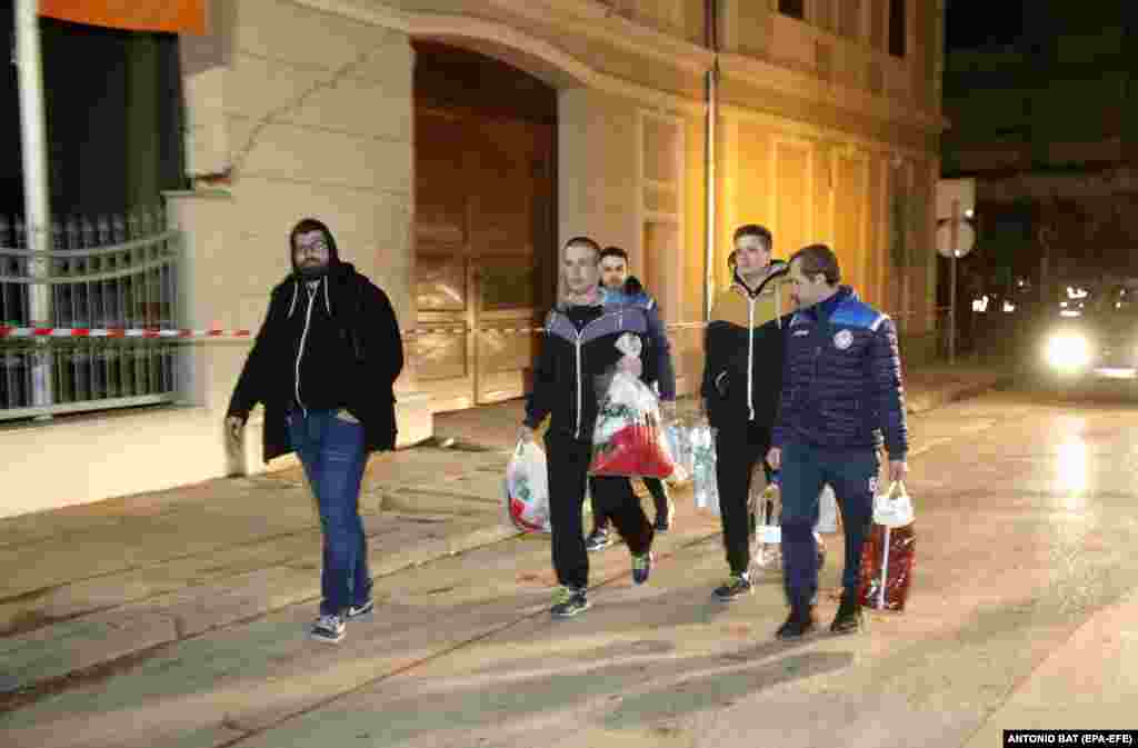 Građani nose torbe sa pokrivačima, hranom i vodom nakon što su zgrade oštećene u zemljotresu u Petrinji u Hrvatskoj, 29. decembra 2020. EPA-EFE / ANTONIO BAT