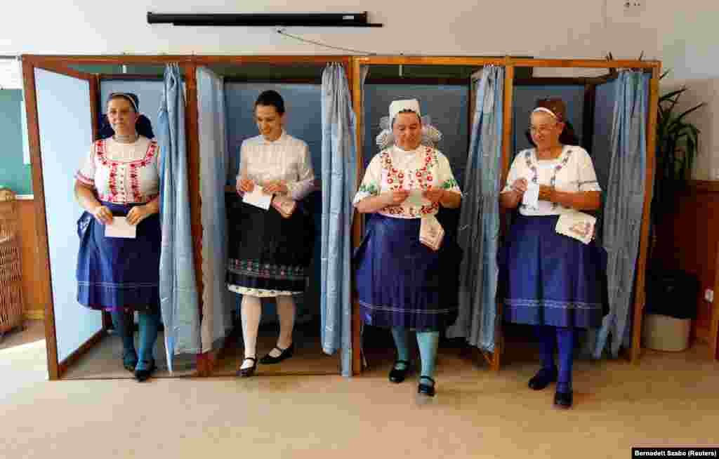 Hungarian women wearing traditional dress leave a voting booth at a polling station during a referendum on EU migrant quotas on October 2. (Reuters/Bernadett Szabo)