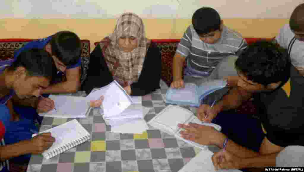 Teacher Nibras Qassim was left partially paralyzed after an illness, but has returned to teaching math at her home in Kut, Iraq. 