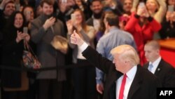 U.S. -- President-elect Donald Trump gives a thumbs up to the crowd as he walks through the lobby of the New York Times following a meeting with editors at the paper in New York, November 22, 2016 