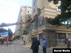 Workers remove polyurethane panels from a building in Baku.
