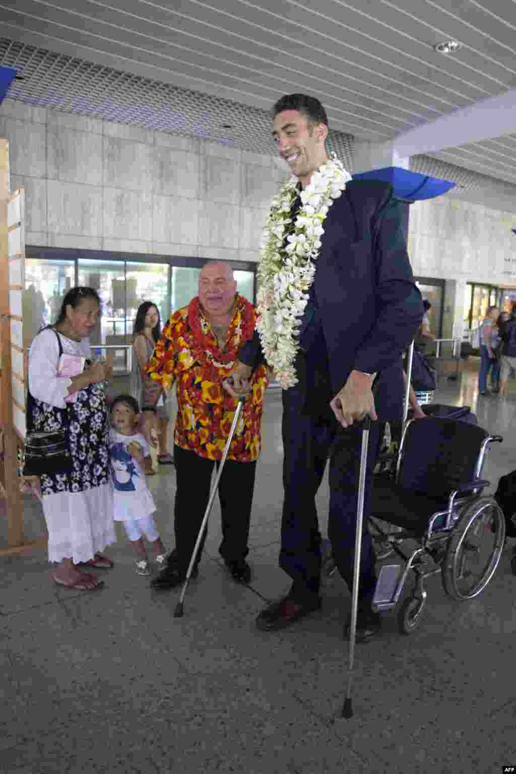 Sultan Kosen, the Guinness World Record holder for tallest living male at 2.51 meters, arrives at the Tahiti Airport for the Magic Circus of Samoa tour. (AFP/Gregory Boissy)