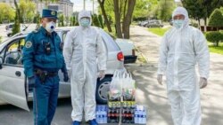 Ташкент базарына дезинфекция жасауға келген арнайы киімдегі адамдар мен полиция қызметкері. 14 сәуір 2020 жыл.