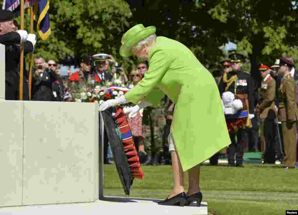 Britain&#39;s Queen Elizabeth lays a wreath during the French-British ceremony at the British War cemetery in Bayeux.