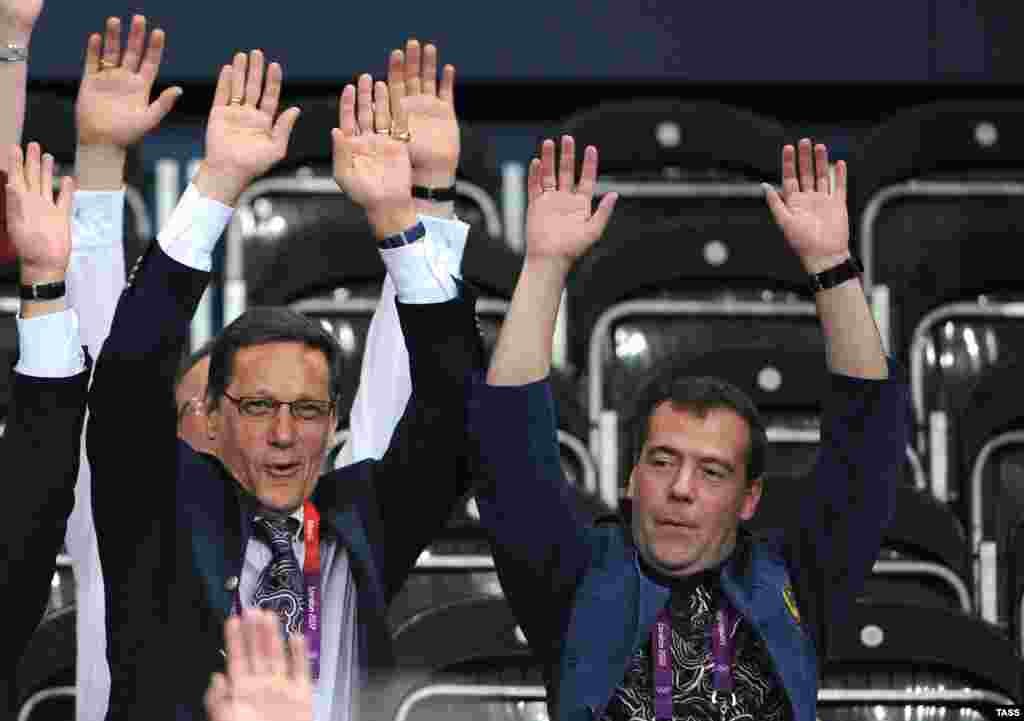 Russian Prime Minister Dmitry Medvedev (left) takes part in a "Mexican wave" during his country's women's volleyball match against Britain at the London Olympics on July 28. (ITAR-TASS/Valery Sharifulin)