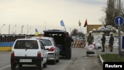 Cars lined up to pass a checkpoint, erected by ethnic Tatars and members of Ukrainian nationalist battalions, outside the settlement of Chonhar, which borders with the territory of Crimea, November 23, 2015.