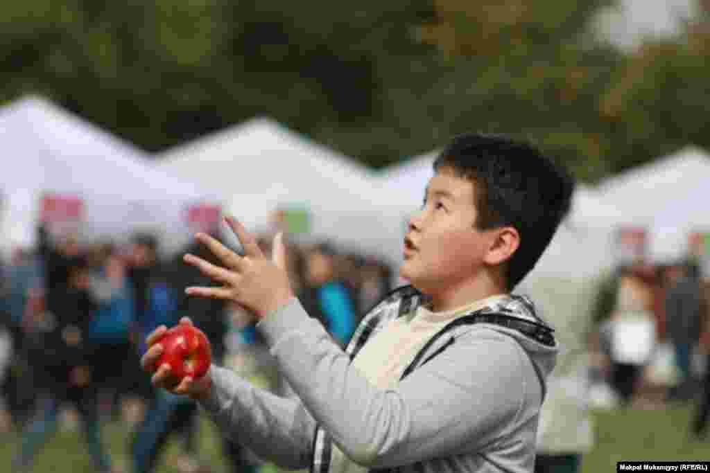 Мальчик жонглирует яблоками. 