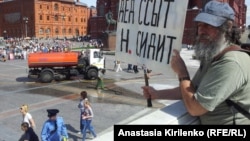 One of the first of the Navalny supporters at Manezh Square, outside the Kremlin in Moscow, on July 18, holds a sign referencing Pussy Riot lyrics saying, "The old man wets his pants [and] N. is in jail."