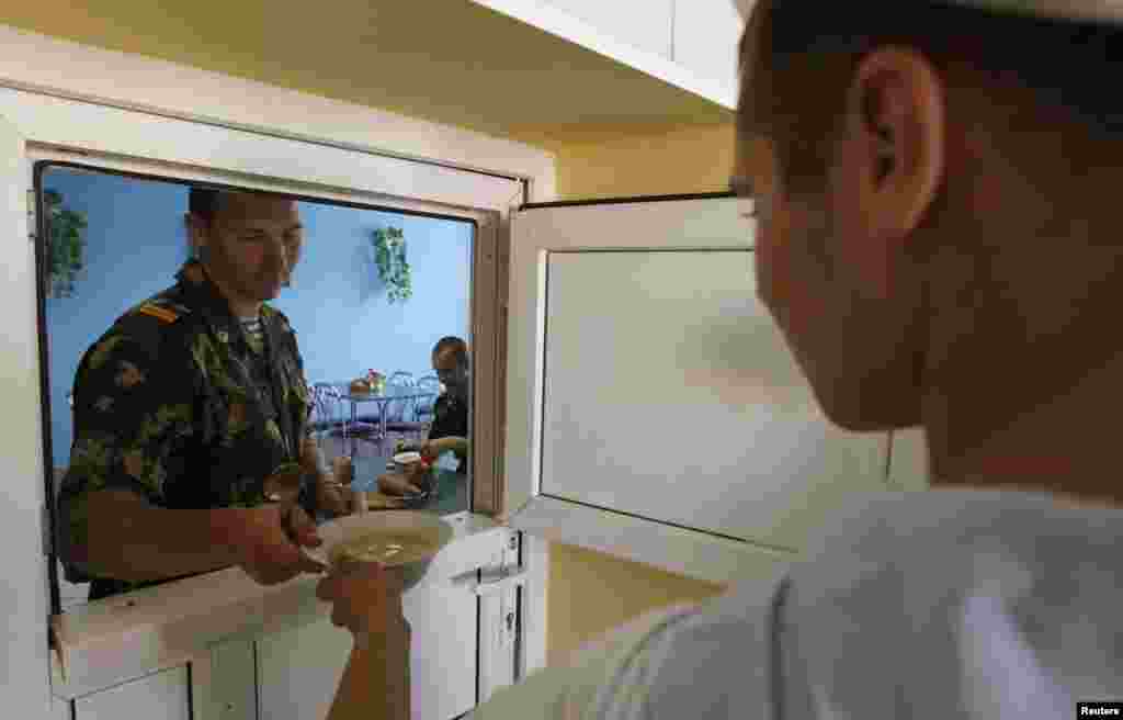 A guard receives his lunch from the post cafeteria.