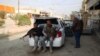 Armed tribesmen and Iraqi police sit in a car as clashes rage on in the Iraqi city of Ramadi, west of Baghdad, on January 2.