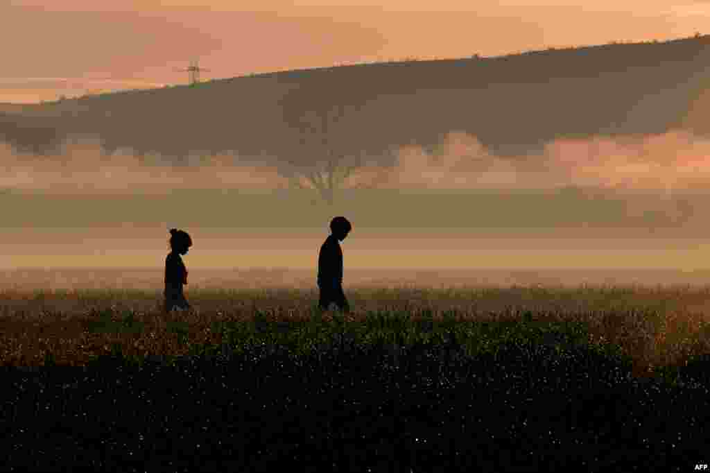 Children walk through a field near a makeshift camp near the Greek village of Idomeni at the Greek-Macedonian border, where thousands of migrants and refugees are stranded. (AFP/Louisa Gouliamaki)