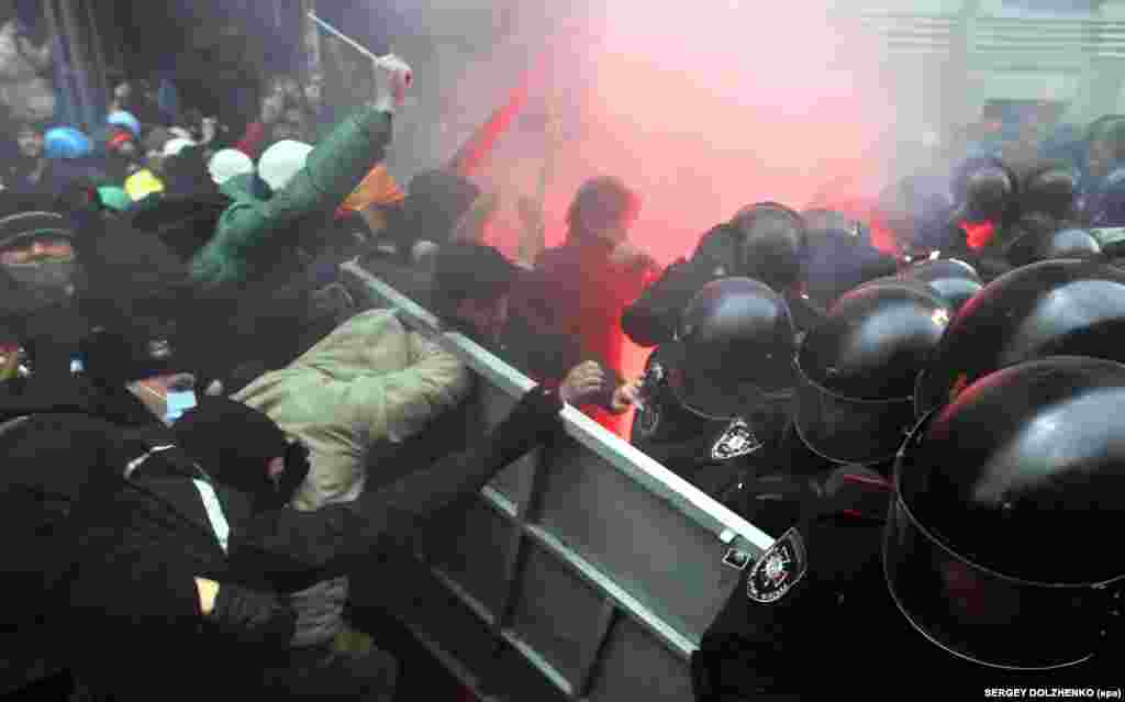 Protesters try to break through police lines close to the building of the presidential administration.