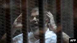 Бывший президент Египта Мохаммед Мурси - на скамье подсудимых. Каир, 14 октября 2014 года.