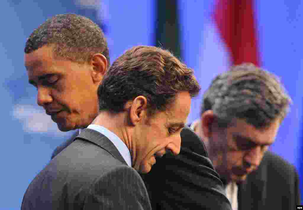 Obama turns the podium over to French President Nicolas Sarkozy as British Prime Minister Gordon Brown stands nearby at the G20 Summit in Pittsburgh, Pennsylvania, on September 25, 2009. The leaders addressed a previously secret Iranian nuclear facility, and demanded that Iran cooperate with international inspections of its nuclear sites.