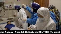 Iran -- Nurses take a sample from Parham, a 7-year-old, to test for the coronavirus disease (COVID-19), at a hospital, in Tehran, Iran, July 8, 2020. 