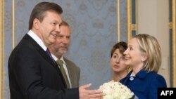 Ukrainian President Viktor Yanukovych (left) presents a bouquet of flowers to U.S. Secretary of State Hillary Clinton in Kyiv.