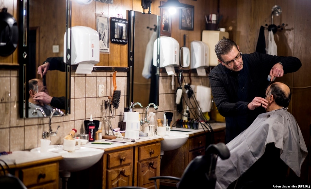 A barber clipping into the evening in Pristina. (Photo by Arben Llapashtica)