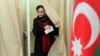 A woman leaves a voting booth at a polling station in Baku.