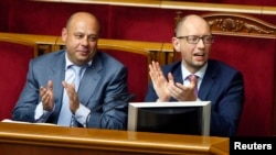 Ukrainian Prime Minister Arseniy Yatsenyuk (right) and Energy Minister Yuriy Prodan during a session in parliament on August 14 which passed laws allowing sanctions to be imposed on Russia. 