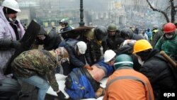 Активісти виносять пораненого товариша під час розстрілу спецпризначенцями людей на Майдані, 20 лютого 2014 року