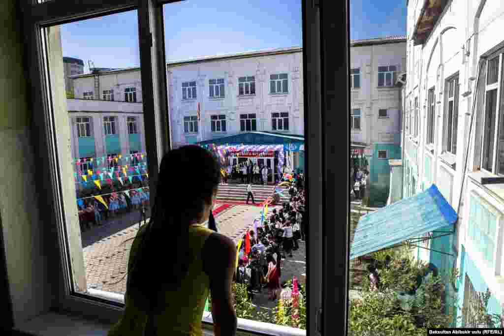 A girl watches a school graduation celebration on May 25 in Bishkek, Kyrgyzstan. (Beksultan Abibakir, RFE/RL)