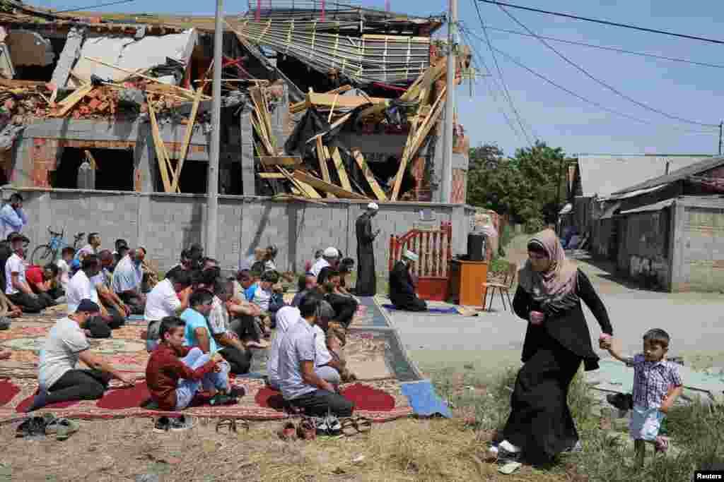 Muslims pray on a street in front of a destroyed, illegally built mosque in the Zemun Polje district of Belgrade, Serbia. (Reuters/Marko Djurica)