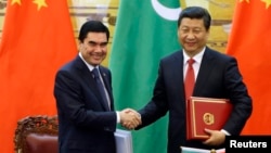 2014-nji ýylyň 12-nji maýynda Türkmenistanyň şol wagtky prezidenti Gurbanguly Berdimuhamedow (çepde) Pekinde Hytaýyň ýolbaşçysy Si Szinping bilen elleşýär. 