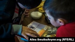 Дети политзаключенного Рефата Алимова рассматривают фотографию своего отца. Крым, поселок Кранокаменка/, октябрь 2017 года