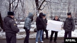 Aleksandr Ryklin (holding sign) was among those detained by police during the individual picket to support Eduard Limonov on November 16.