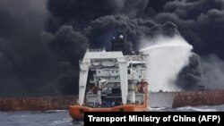 CHINA -- The Chinese offshore supply ship "Shen Qian Hao" sprays foam on the burning oil tanker "Shanchi" at sea off the coast of eastern China, January 12, 2018