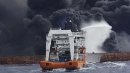 CHINA -- The Chinese offshore supply ship "Shen Qian Hao" sprays foam on the burning oil tanker "Shanchi" at sea off the coast of eastern China, January 12, 2018