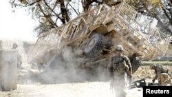 U.S. Army soldiers secure the scene after an improvised explosive device exploded during a road-clearance patrol in Logar Province.