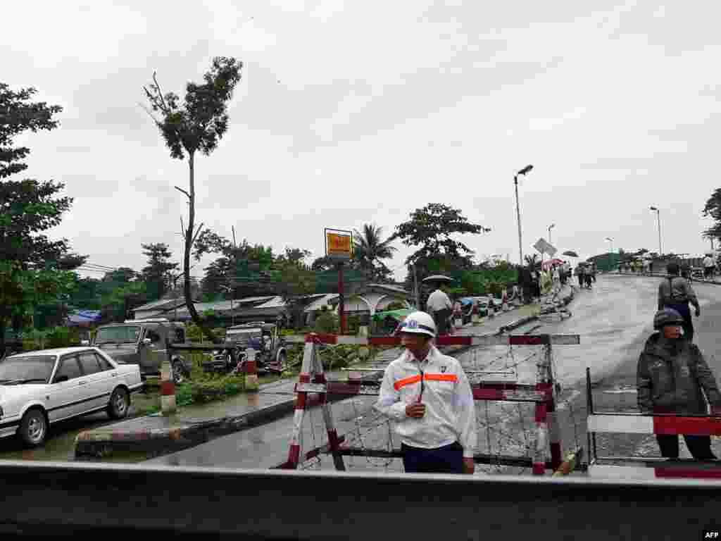 Myanmar - Myanmar policemen man a checkpoint on a road leading to the Insein jail at Insein Township in Yangon, 11Aug2009 - Hkg2636760 Object name MYANMAR - POLITICS - SUUKYI MYANMAR, Yangon : MYANMAR OUT Myanmar policemen man a checkpoint on a road leading to the Insein jail at Insein Township in Yangon on August 11, 2009. Myanmar democracy icon Aung San Suu Kyi was ordered to stay under house arrest for 18 months after a prison court convicted the Nobel laureate at the end of her internationally condemned trial. The court at Yangon's Insein jail sentenced her to three years imprisonment and hard labour for breaching the terms of her house arrest following an incident in which a US man swam to her lakeside residence in May, but junta chief Than Shwe signed a special order allowing her to serve just half that time, under house arrest. MYANMAR OUT AFP PHOTO