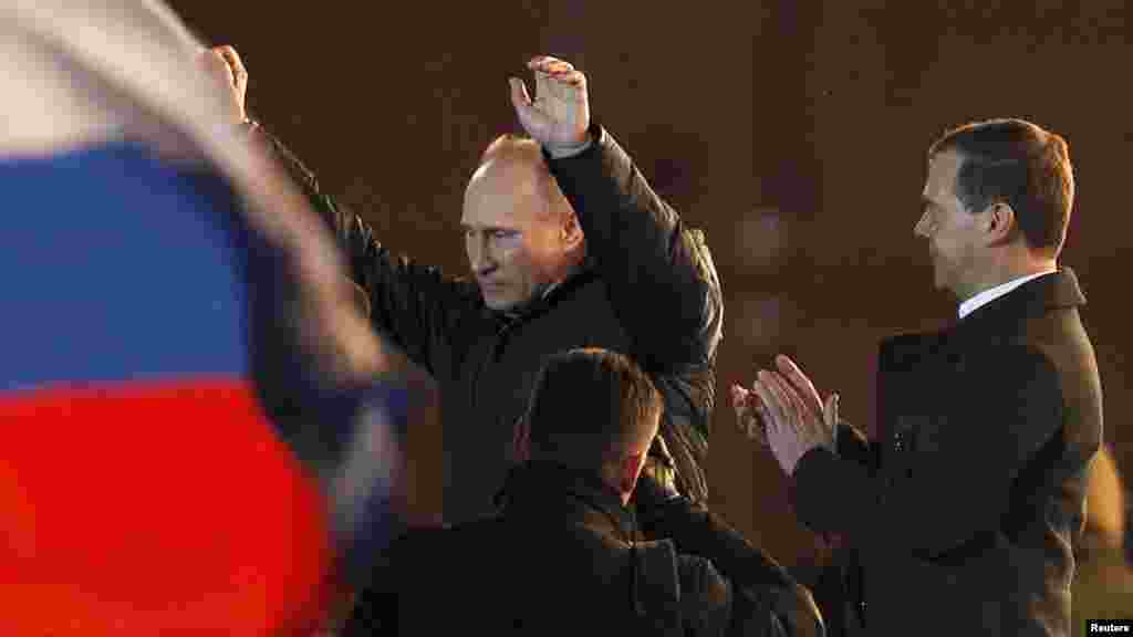 Vladimir Putin (left) greets supporters as President Dmitry Medvedev applauds at the Manezh Square rally near the Kremlin on March 4. (REUTERS/Denis Sinyakov)