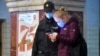 Москва, женщина показывает полицейскому QR-код для поездки в транспорте, 17 апреля 2020 года