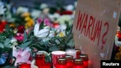 A sign reading "Why?" is placed at the Christmas market in Berlin, the site of the deadly truck attack.