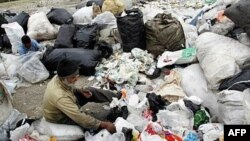 Afghan workers sort through waste plastic in outside Tehran.