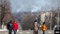 Местные жители смотрят на дым от пожара и взрывов на складах боеприпасов в Балаклее Харьковской области Украины, 23 марта 2017 года