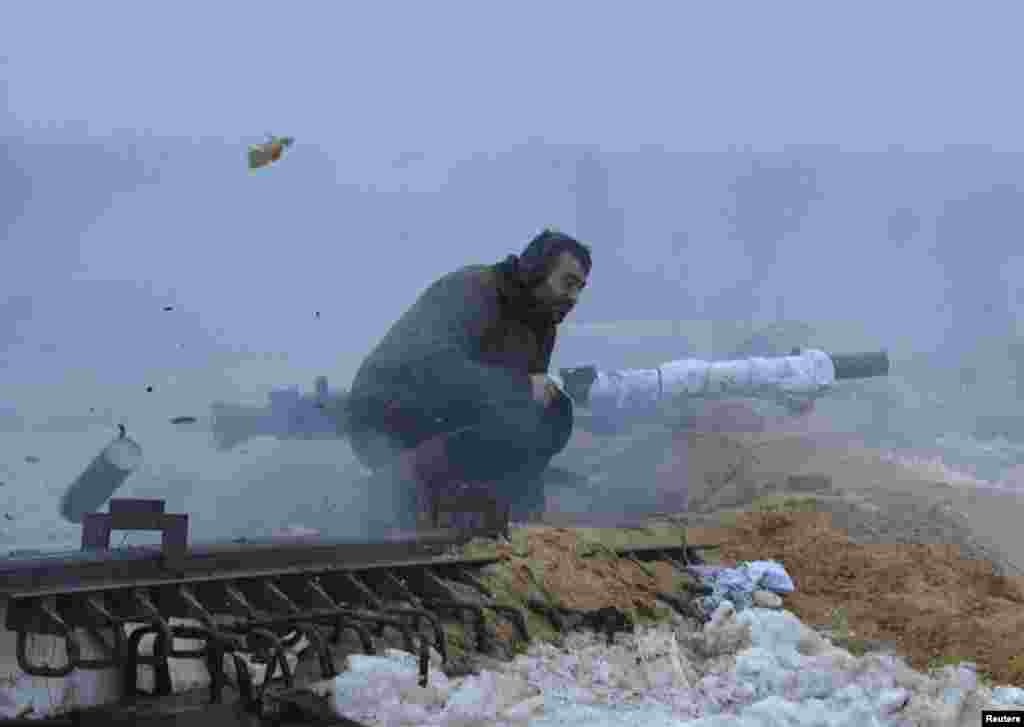 A Ukrainian serviceman fires a weapon during fighting with pro-Russian separatists in the village of Pesky near Donetsk. Ukrainian President Petro Poroshenko accused Russia this week of sending 9,000 troops to back separatist rebels. (Reuters/Oleksandr Klymenko)