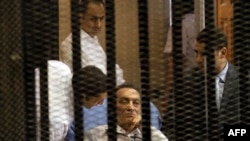 الرئيس المصري السابق حسني مبارك ونجلاه جمال وعلاء أثناء إعادة محاكمتهم في القاهرة.