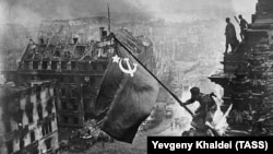 A staged photograph of Soviet soldiers raising the hammer-and-sickle flag above the building after it was seized remains one of the most iconic photographs to emerge from World War II, known in Russia as the Great Patriotic War.