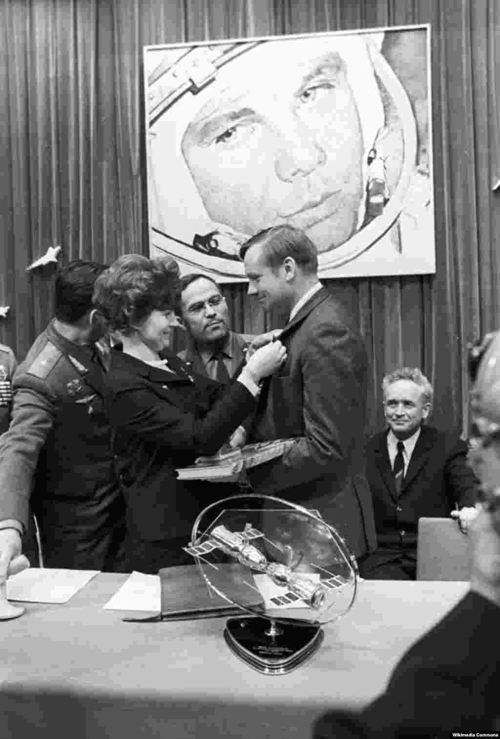 Tereshkova pins a badge on U.S. astronaut Neil Armstrong during his visit in 1970 to the Soviet training center, Star City. More than 500 people from 38 countries have traveled into space.