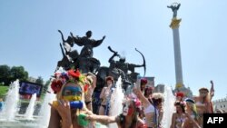 Активисты движения за права женщин "Фемен", одетые как футбольные фанаты, в фонтане на площади Независимости в Киеве. 14 июля 2011 года.