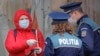 ROMANIA -- A woman shows identity papers to a police patrol as the country's army was called to assist the police in enforcing a full day lockdown, in Bucharest, March 25, 2020