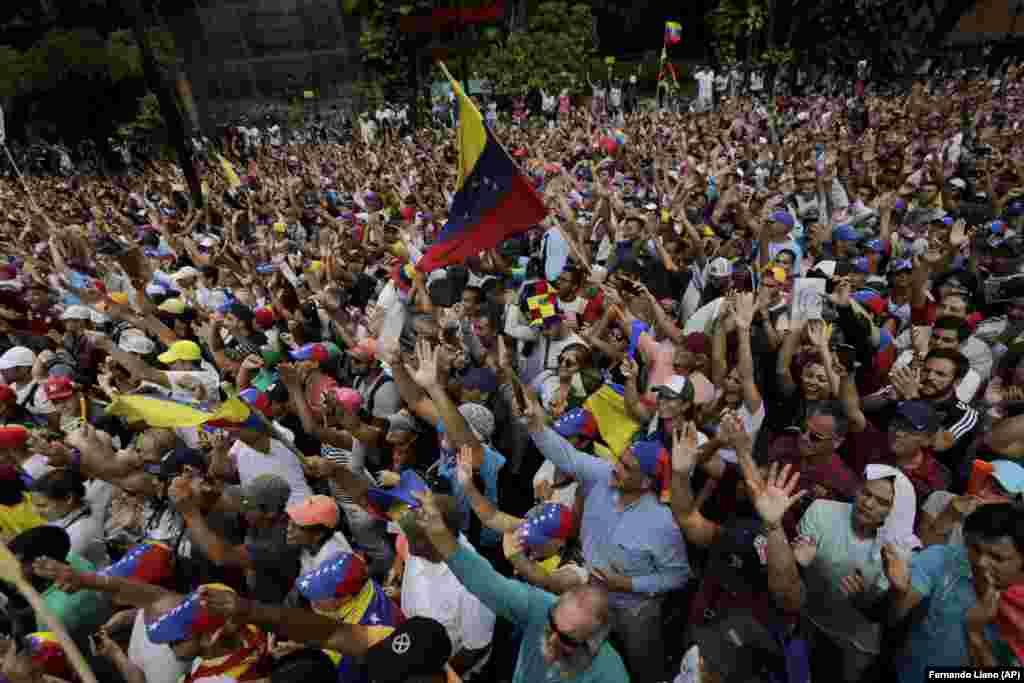 Antigovernment protesters hold up their hands as Guaido took an oath swearing himself in as acting president.&nbsp;