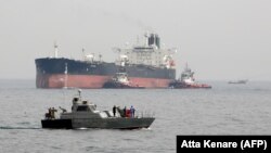 FILE - An Iranian military speedboat patrols the waters as a tanker prepares to dock at the oil facility in the Kharq Island, March 12, 2017