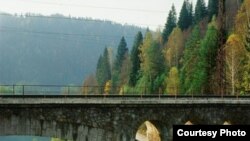 Поезд движется через древние уральские села: каменный арочный мост XIX века выглядит частью горного рельефа. [Фото — <a href="http://www.photographer.ru/events/afisha/2924.htm" target=_blank>PHOTOGRAPHER.RU</a>]