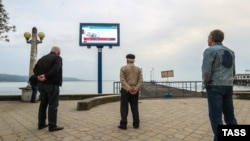 Locuitori ai Abhaziei urmăresc televizorul în parc, martie 2017 